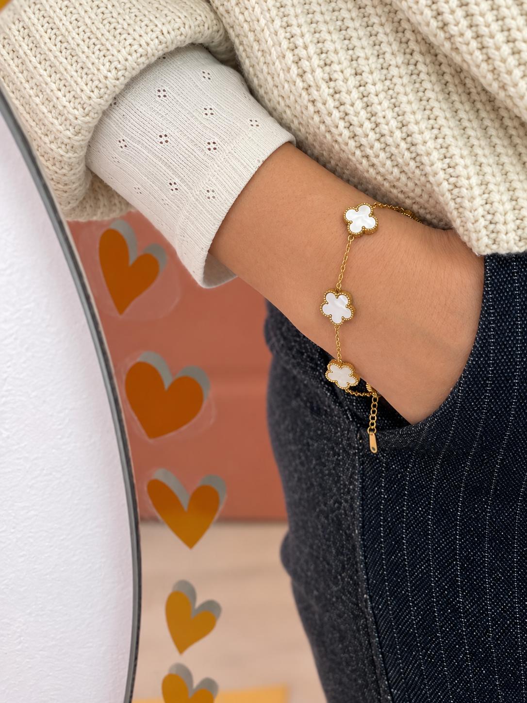 Bracelet chaîne fine dorée à trois trèfles en nacre blanche, porté au poignet — Glaia Collection, Guer