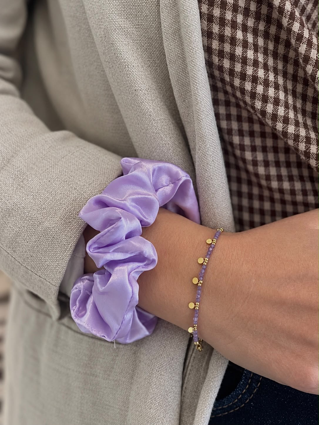 Bracelet à fines perles facettées parme et pastilles dorées, porté au poignet — Glaia Collection, Guer